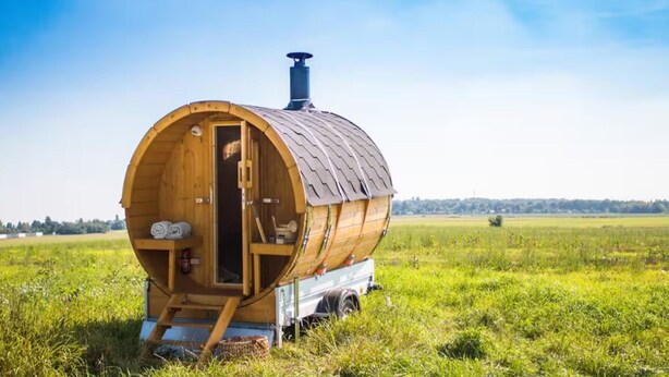 A wooden barrel-shaped structure with a chimney, a door, and a small set of stairs leading up to it. - VILLA FOREST & LAKES near Berlin - Country villa with horses, fireplace & peace! (Marienwerder-Ruhlsdorf)