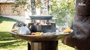 A portable grill with a pot on top, surrounded by various foods and vegetables, set outdoors. - VILLA FOREST & LAKES near Berlin - Country villa with horses, fireplace & peace! (Marienwerder-Ruhlsdorf)