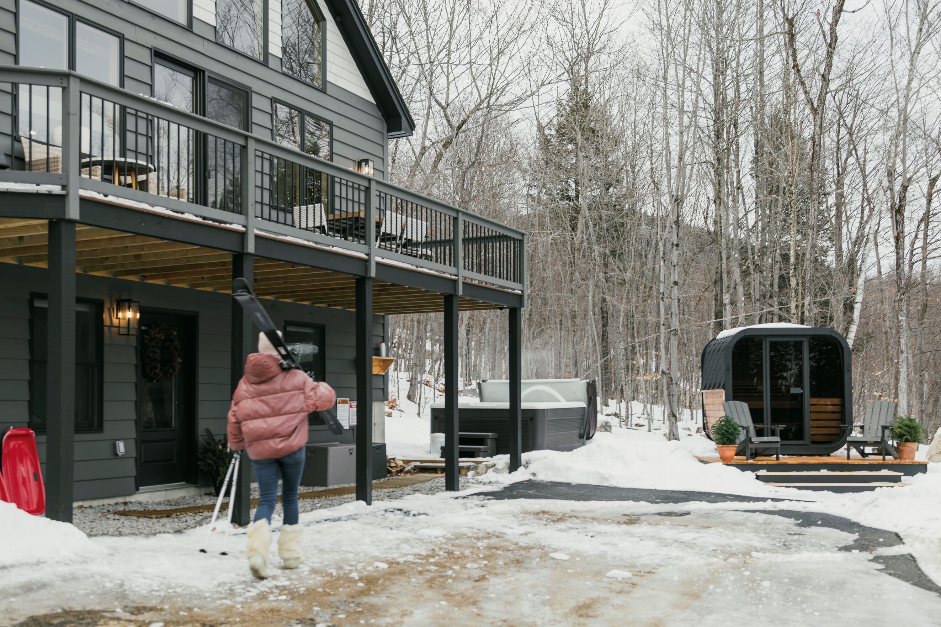 A two-story house with a covered porch and a small cabin-like structure.