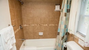 A bathroom with a bathtub, toilet, and shower.