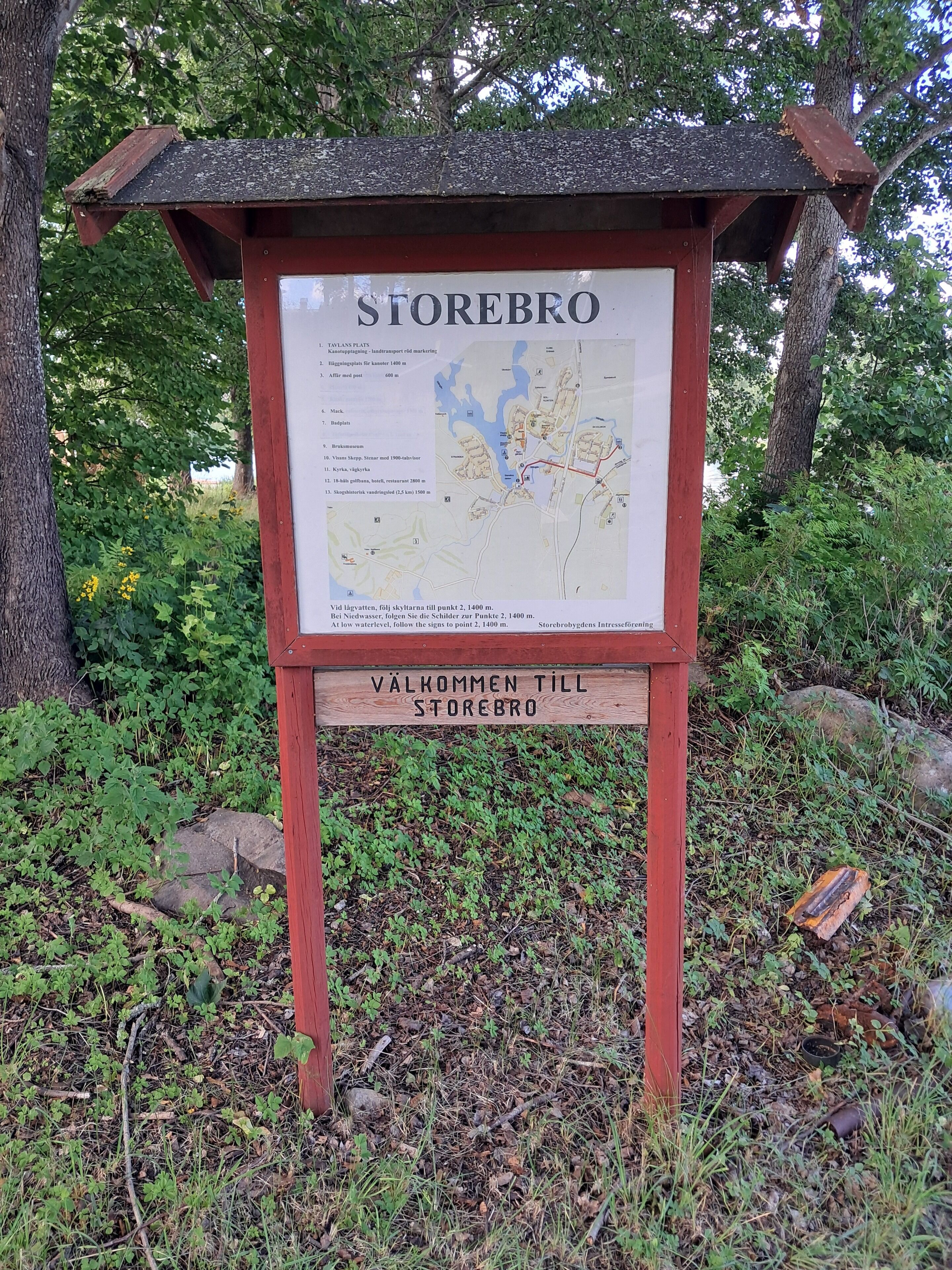Un letrero de madera con un mapa y texto que indica las indicaciones para llegar a Storebro.