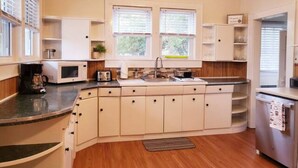 Une cuisine moderne avec des meubles blancs, un four à micro-ondes encastré et un évier.