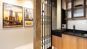 A modern kitchen with wooden cabinets, a black countertop, and a stainless steel sink.