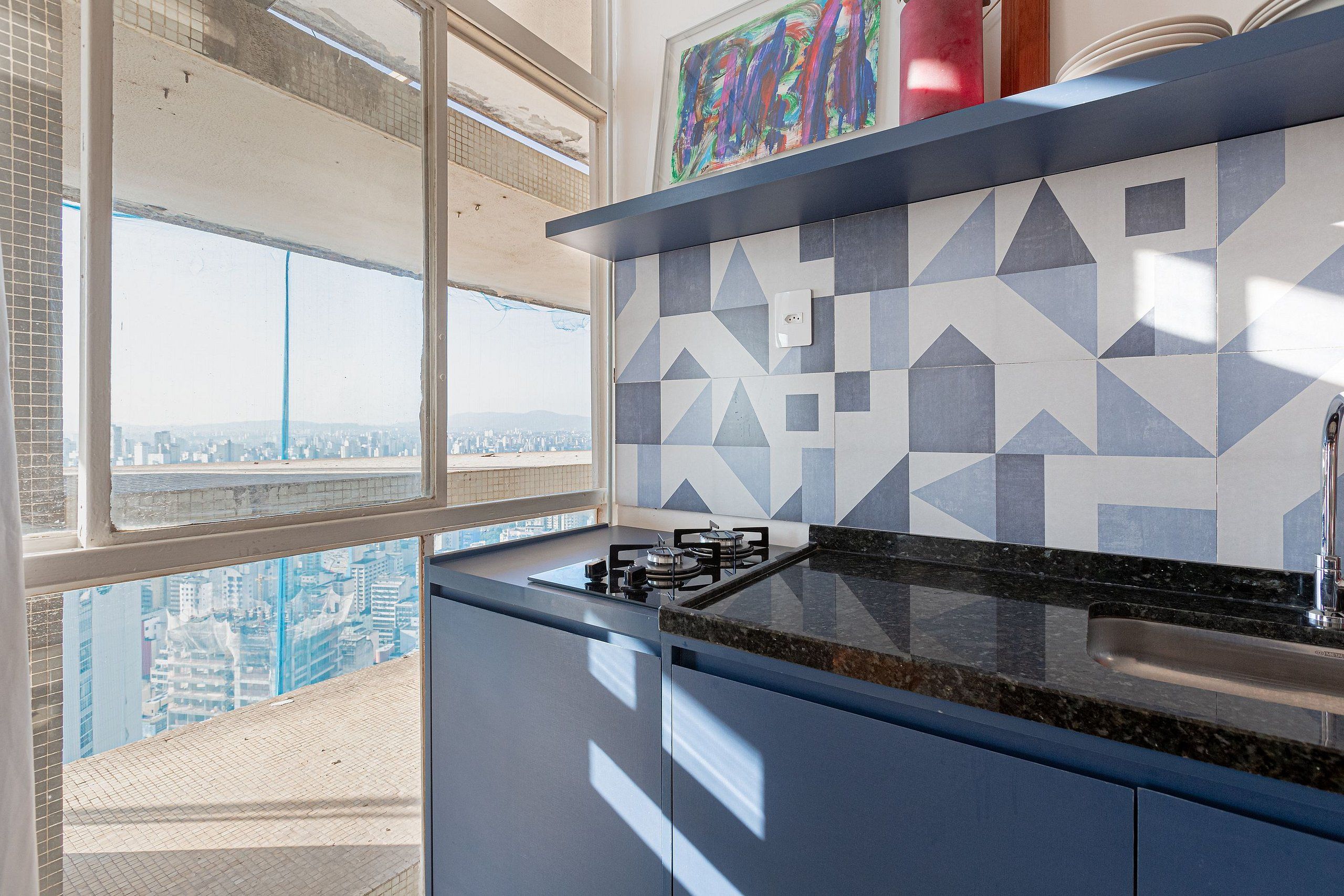 Una cocina moderna con vistas a la ciudad, salpicadero geométrico y estufa a gas.