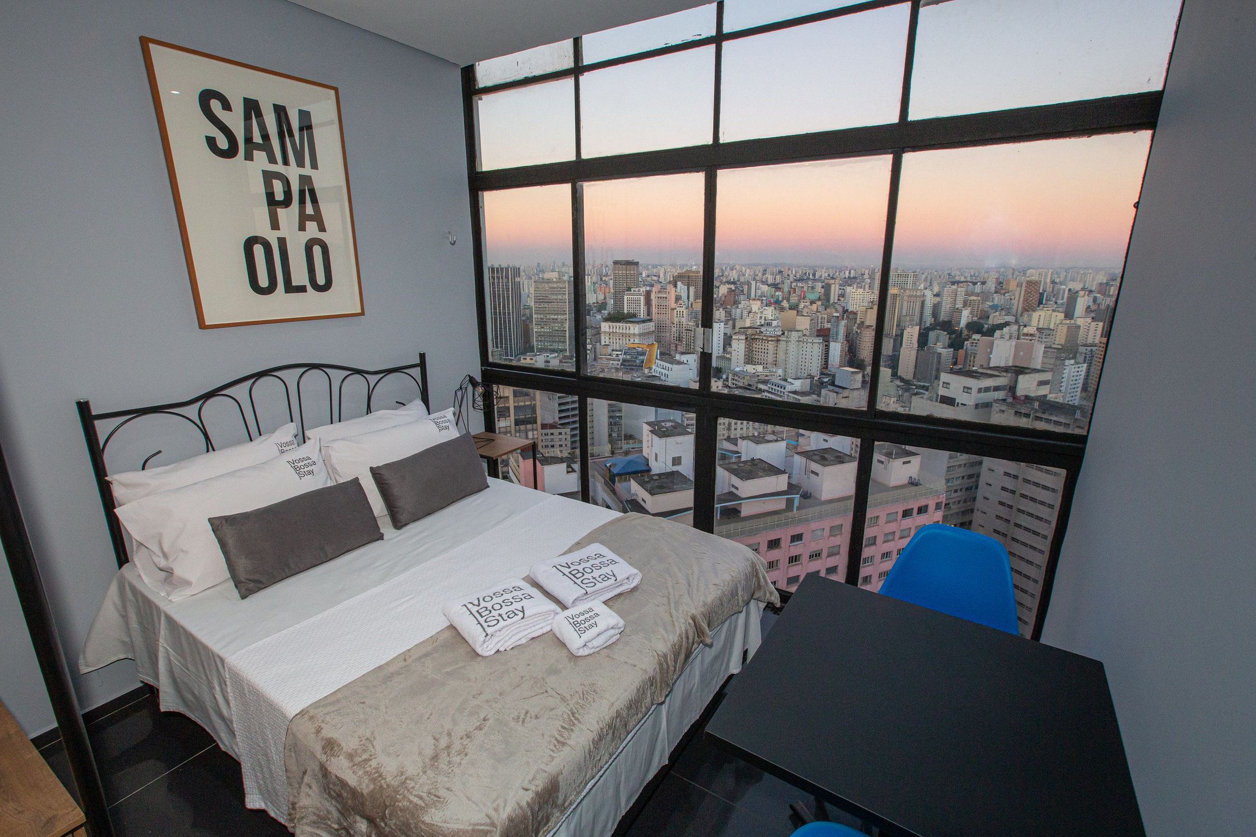 Ein Hotelzimmer mit großem Fenster und Blick auf die Stadt.