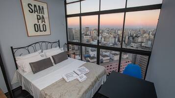 Ein Hotelzimmer mit großem Fenster und Blick auf die Stadt.