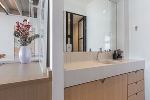 Une salle de bain moderne avec un grand miroir, un lavabo et des meubles en bois.