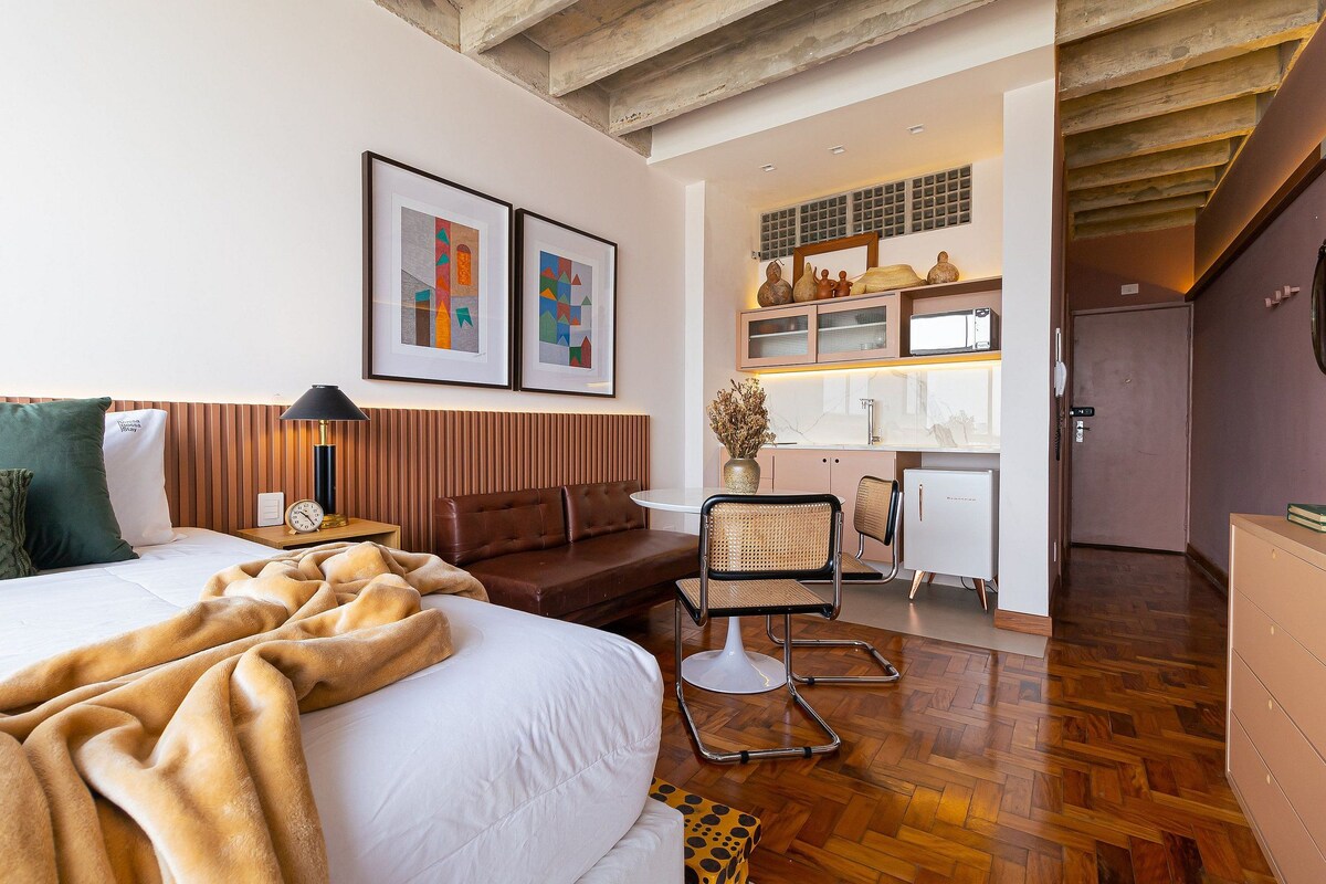 Une chambre d’hôtel moderne dotée d’un grand lit, d’un canapé, d’un coin repas et d’une cuisine.