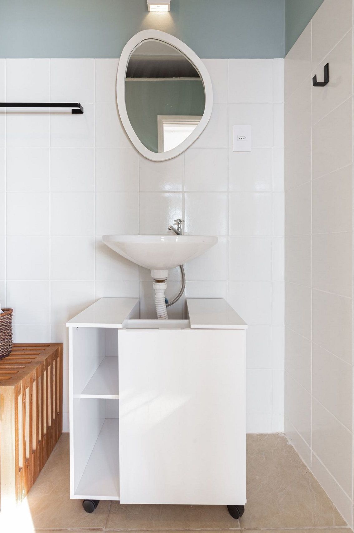 A bathroom with a white sink, a mirror, and a towel rack.