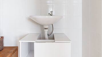 A bathroom with a white sink, a mirror, and a towel rack.