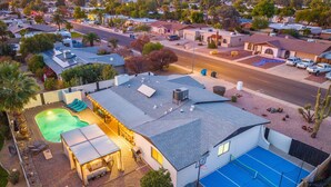 A residential area with a house featuring a swimming pool, tennis court, and a covered patio area. - PuttPutt, Pickleball, Basketball, Ping Pong & Game Room! Pool & Spa! (Scottsdale)