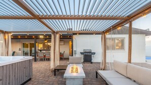 An outdoor patio with a pergola, seating, a hot tub, and a grill area. - PuttPutt, Pickleball, Basketball, Ping Pong & Game Room! Pool & Spa! (Scottsdale)