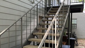 A concrete staircase with metal railings leading to a covered outdoor area.