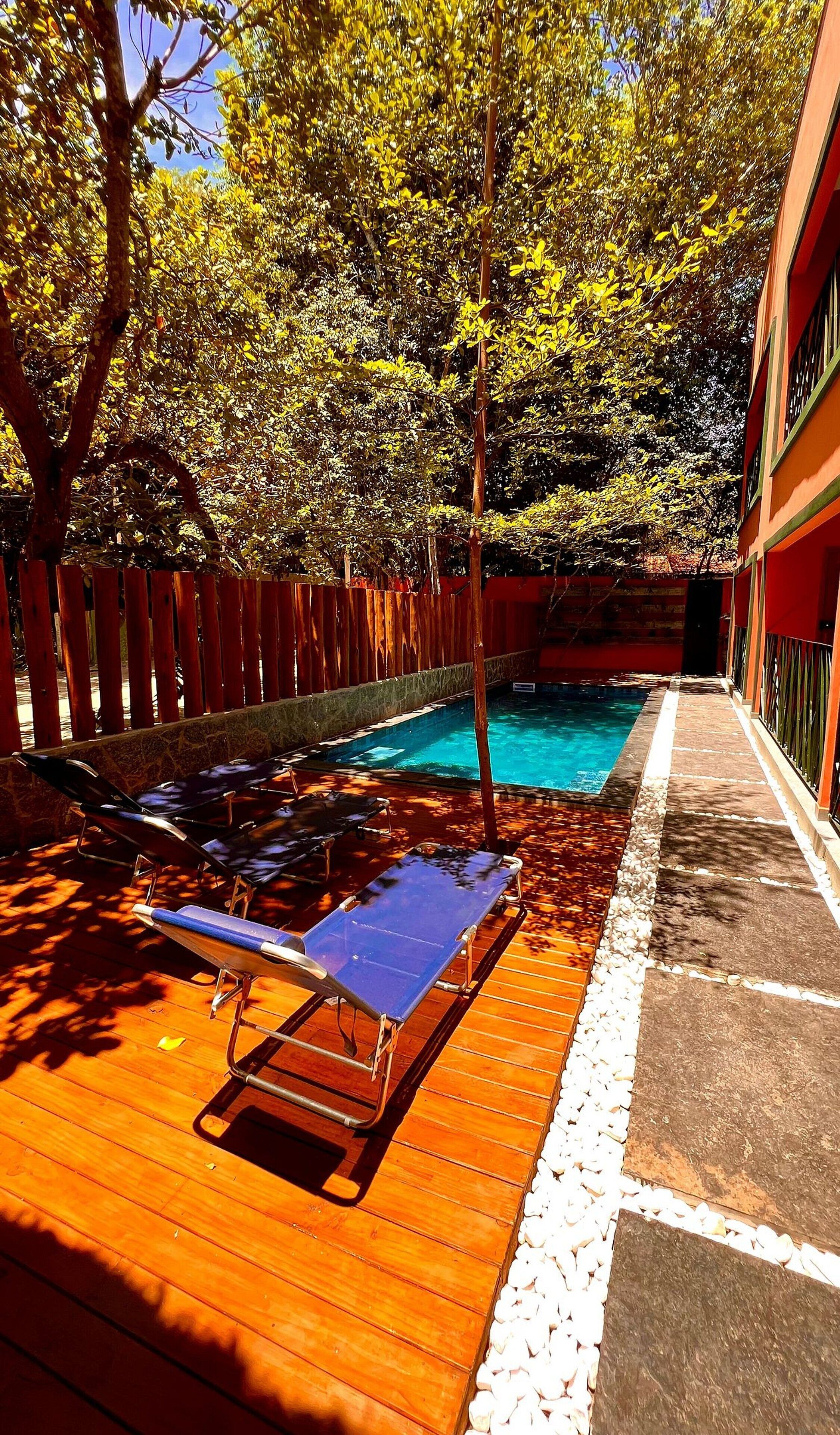A swimming pool with lounge chairs and a wooden deck.