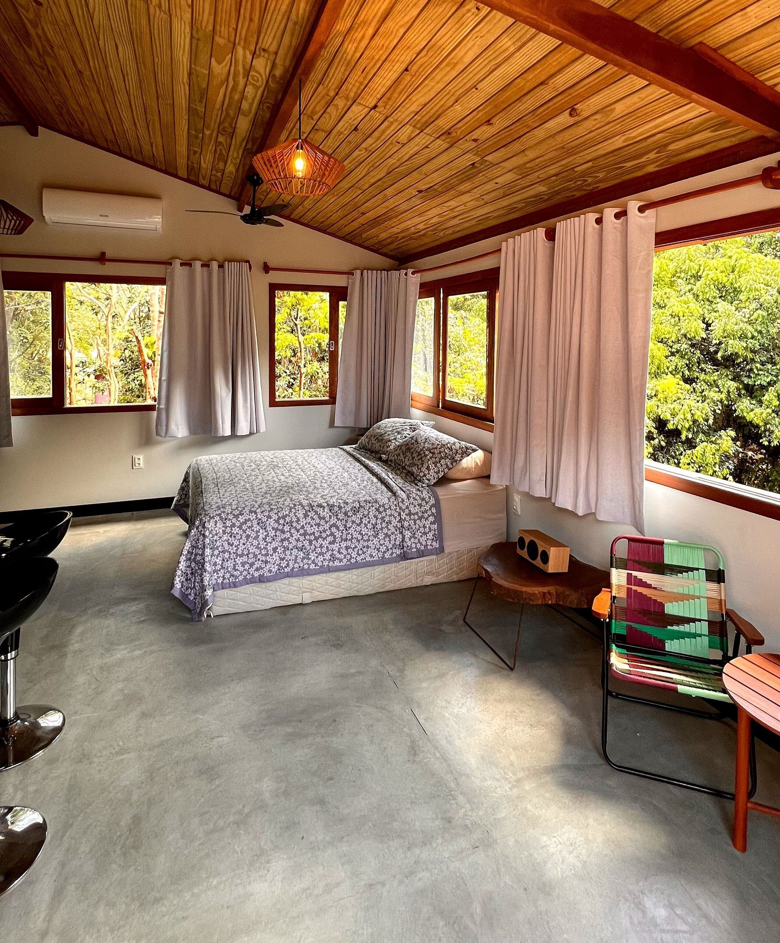 A bedroom with a bed, a chair, a window, and a ceiling fan.