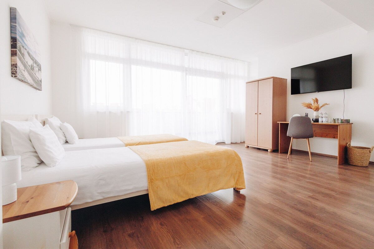 Une chambre d’hôtel équipée d’un lit, d’un bureau, d’une télévision et d’une armoire.
