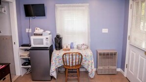 A compact kitchen with a microwave, coffee maker, and a small table with a chair. - Cabin in the heart of the Hudson Valley, Cabin 4 (Newburgh)