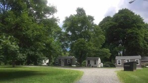 A gravel driveway leading to a row of houses surrounded by trees. - Cabin in the heart of the Hudson Valley, Cabin 4 (Newburgh)