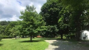 A grassy area with a gravel path leading to a white building. - Cabin in the heart of the Hudson Valley, Cabin 4 (Newburgh)