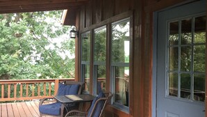 A wooden cabin with a porch, two wicker chairs, a table, and a blue door. - Perfect Cabin 5 minutes to Blanchard Springs Nat. Park (Mountain View)