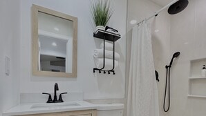 Un baño moderno con inodoro, lavamanos y ducha.