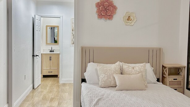 Un dormitorio con cama, ventilador de techo, mesita de noche y espejo.