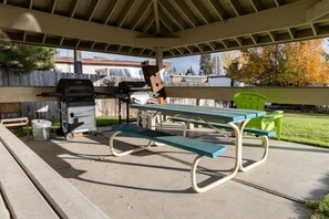A covered patio area with picnic tables and a barbecue grill. - McCall Suite Spot: 1-bedroom with indoor fireplace (McCall)