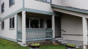 Un edificio a due piani con un portico coperto e un garage.