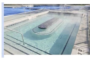 A swimming pool with clear water, a diving board, and a lifeguard stand. - Sun Valley Adventure Condo (Sun Valley)