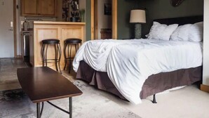 A bedroom with a bed, a desk, and a kitchenette. - Sun Valley Adventure Condo (Sun Valley)
