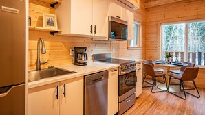 Une cuisine moderne avec des meubles en bois, un lave-vaisselle, un four et un coin repas avec des chaises.