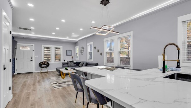A modern kitchen with a marble countertop, a built-in sink, and a pendant light. - Spacious House in Charlotte Close to NoDa District (Charlotte)