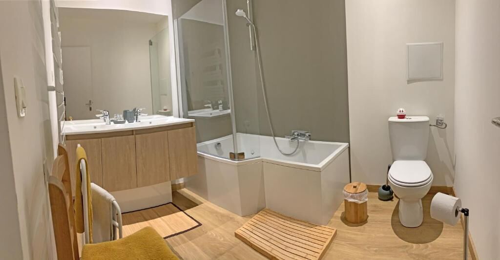 A modern bathroom with a bathtub, toilet, and sink.