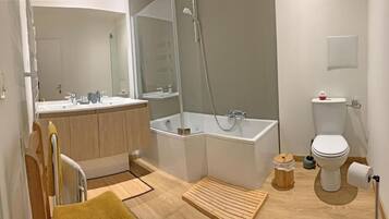 A modern bathroom with a bathtub, toilet, and sink.