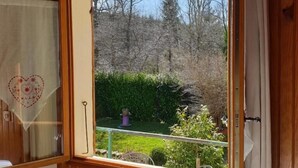 A wooden room with a large window, a radiator, and a curtain. - Les Tables Aux Vaches (La Salvetat-sur-Agout)