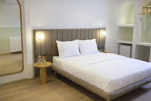 Un lit bien fait, avec du linge de lit blanc, une tête de lit en bois et deux lampes de chevet.