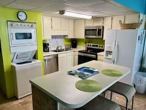 Une cuisine compacte équipée d’un four à micro-ondes, d’un four et d’un réfrigérateur.
