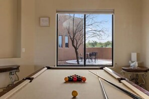 Enjoy a game of pool with a view of the outdoor patio area through the large window.