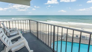 Un balcón con piscina y vista a la playa.