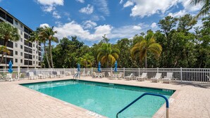 A rectangular swimming pool with a blue border, surrounded by a white fence. - Estero Cove 132 - Beautifully Updated!! 2 Bedroom Condo by RedAwning (Fort Myers Beach)