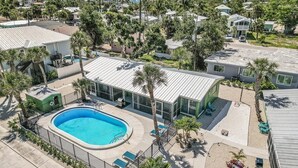 A residential area with a swimming pool, palm trees, and houses. - 171 Washington ~ Dune Our Thing ~ Unit C ~ Fabulous Pool Home! 2 Bedroom Home by RedAwning (Fort Myers Beach)
