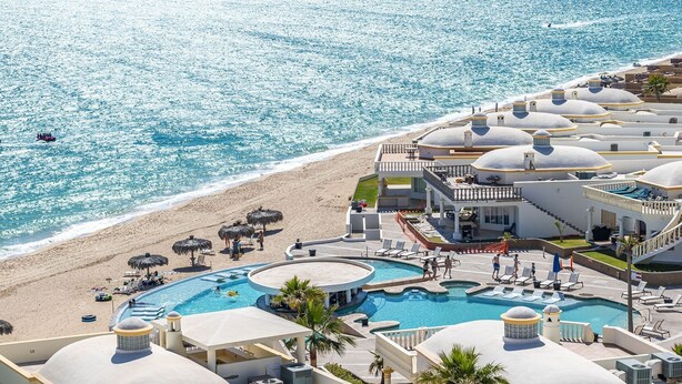 Un resort con piscina, playa y edificios con cúpulas.