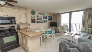 Un espacio habitable compacto con kitchenette, comedor y zona de estar.
