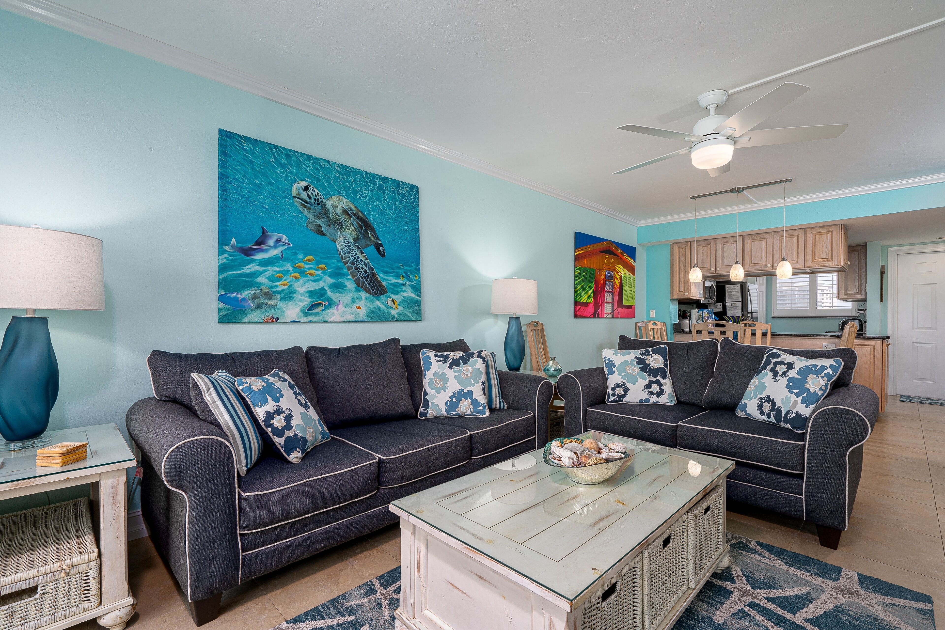 A living room with two sofas, a coffee table, and a painting of a sea turtle.