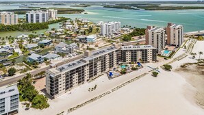 A coastal resort with multiple high-rise buildings, a beach, and a marina. - Welcome To Carlos Point # 324 2 Bedroom Condo by RedAwning (Fort Myers Beach)