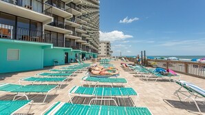 A rooftop pool area with multiple lounge chairs and a view of the ocean. - Royal Garden Resort 515 2 Bedroom Condo by RedAwning (Murrells Inlet)