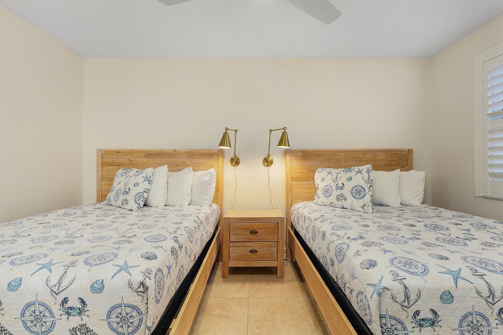 A bedroom with two beds, each with matching headboards and bedside tables.