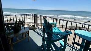 A balcony with a view of the beach, featuring outdoor furniture and a potted plant. - Royal Garden Resort 209 2 Bedroom Condo by RedAwning (Murrells Inlet)