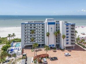A hotel with a pool, beach view, and parking area. - Welcome To Beach Villa's # 603 Vacation Rental - 250 Estero Blvd 2 Bedroom Condo by RedAwning (Fort Myers Beach)