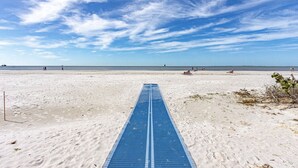 Une plage avec une piste bleue qui longe le rivage et mène à l’eau.